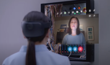 Opératrice avec un casque HoloLens 2 en appel visio avec une experte à distance grâce à Remote Assist