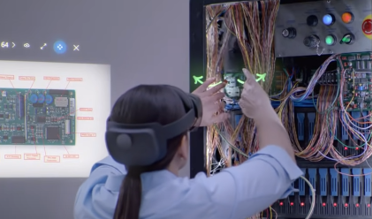 Opératrice avec un casque HoloLens 2 qui réalise une tâche sur un tableau électrique grâce aux instructions d'un expert distant en appel grâce à Remote Assist