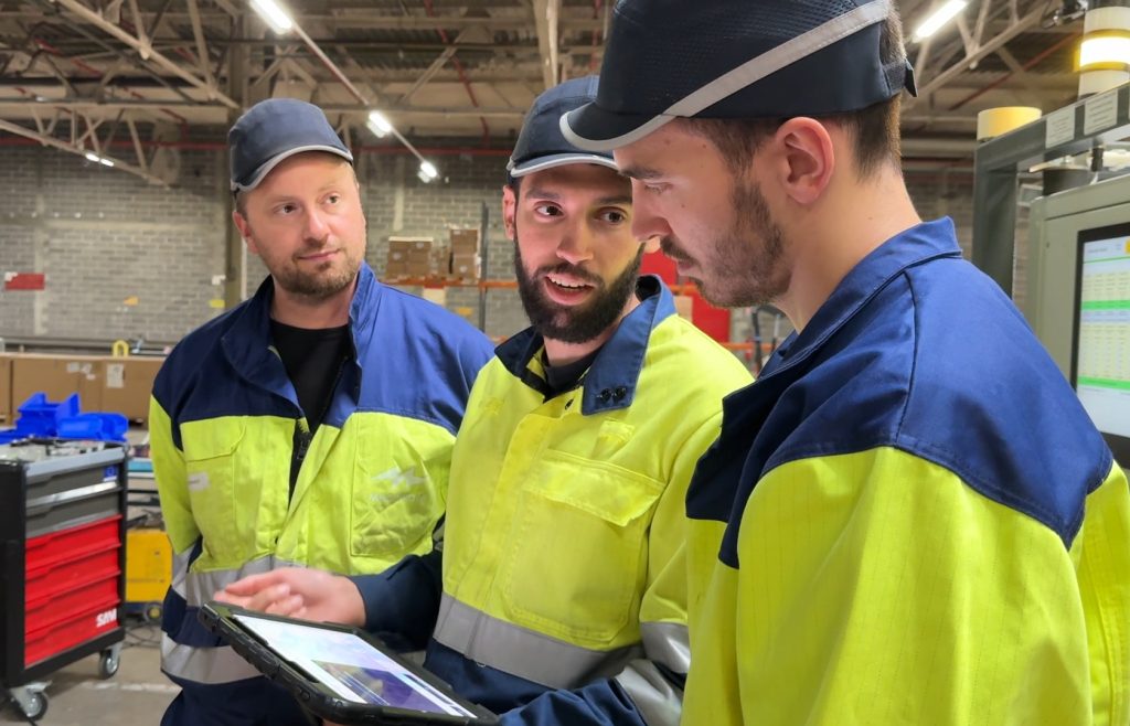 3 personnes autour d'une tablette suivant un tutoriel pour se former sur une nouvelle machine